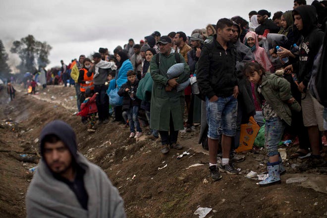 People queue in order to clear a police line after entering Croatia from Serbia in Strosinci, Croatia, Saturday, Sept. 26, 2015. Conciliation replaced confrontation among European nations which have clashed over their response to a wave of migration, but confusion faced many asylum-seekers streaming into Croatia on Saturday in hopes of chasing a new future in Western Europe. (AP Photo/Marko Drobnjakovic)