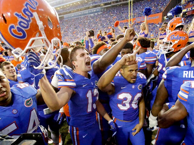 Florida players including linebacker Daniel McMillian (13) and wide receiver Roger Dixon (36) celebrate after defeating Tennessee 28-27 in an NCAA college football game, Saturday, Sept. 26, 2015, in Gainesville, Fla. Florida won 28-27. (AP Photo/John Raoux)