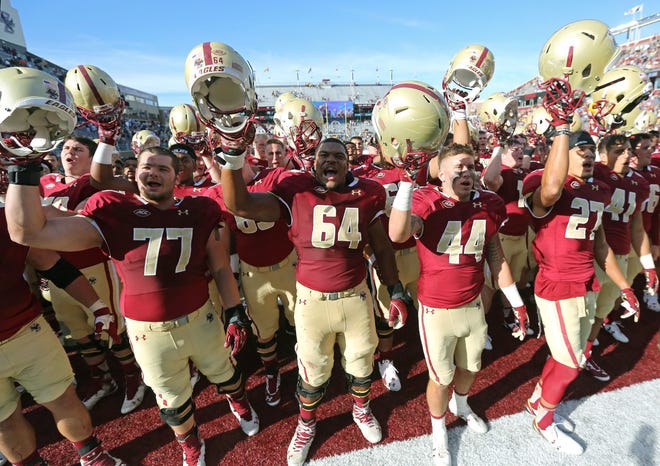 Boston College players raise their helmets to their fans after beating Northern Illinois. THE ASSOCIATED PRESS
