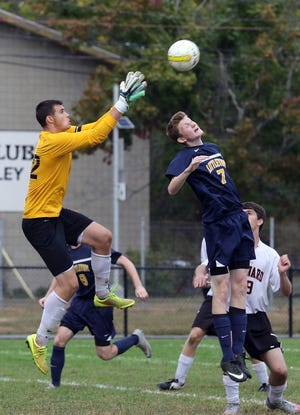 Maynard goalie Ernie Jones goes up to catch the ball as Littleton's Cole Armstrong tries to head it past him. The two teams met in Maynard Tuesday afternoon, Sept. 22, 2015. Wicked Local Staff Photo/Ann Ringwood