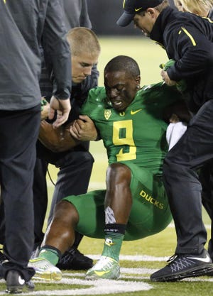 Oregon's Byron Marshall is helped off the field after injuring his lower leg during the third quarter at Autzen Stadium in Eugene on Saturday, September 26, 2015. (Andy Nelson/The Register-Guard)