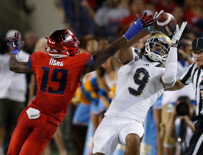 UCLA wide receiver Jordan Payton makes a catch in front of Arizona cornerback DaVonte' Neal during the second half of their game Saturday in Tucson, Ariz. (AP Photo/Rick Scuteri)