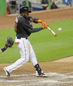 Miami Marlins' Marcell Ozuna hits a solo home run against the Atlanta Braves in the seventh inning Sunday in Miami. The Marlins won 9-5. (AP Photo/Alan Diaz)
