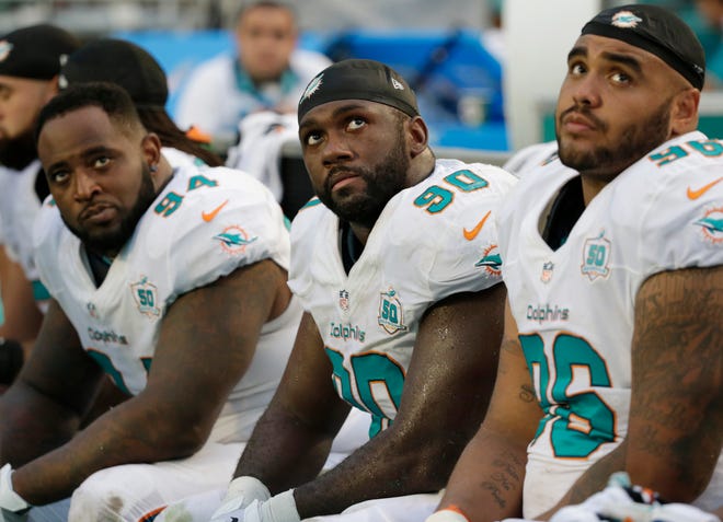 Miami Dolphins defensive tackles C.J. Mosley (94), Earl Mitchell (90) and A.J. Francis (96) looks up during the second half of an NFL football game against the Buffalo Bills, Sunday, Sept. 27, 2015 in Miami Gardens, Fla. The Bills defeated the Dolphins 41-14.