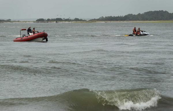 Tybee Island Ocean Rescue first responders search the water for a missing person near where the Back River and the Atlantic Ocean meet. Ocean Rescue lifeguards pulled five people out of the water Sunday evening after they were stranded near a sand bar during a ceremony. Two people died. (Dash Coleman/Savannah Morning News)