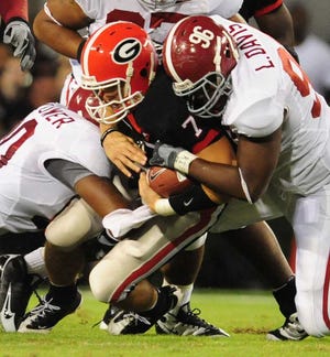 David Manning/Staff Quarterback Matthew Stafford is brought down after a scramble by lineman Luther Davis as the #3 Georgia Bulldogs lose to the #9 Alabama Crimson Tide 41-30 at Sanford Stadium in Athens on Saturday, September 27, 2008.
