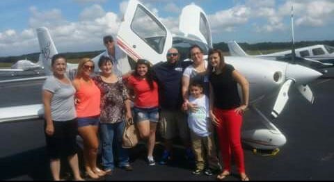 Surrounding P.J. Moura in front the airplane are, from left, aunt Patti Neubauer, cousin Alyssa Rivard, grandmother Toni Neubauer, sister Hannah Moura, Dad Pedro Moura Sr., Mom Sarah Montgomery, friend Jenn Finnerty and pilot Chris Steward, the group gets ready to see the little boy, now in remission from cancer, take to the clouds.