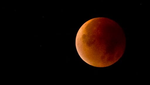The Earth's shadow obscures the view of a so-called supermoon during a total lunar eclipse over Antwerp, Belgium, Monday, Sept. 28, 2015. Supermoon, or perigee moon, is the name given when the full or new moon comes closest to the Earth making it appear bigger. (AP Photo/Virginia Mayo)