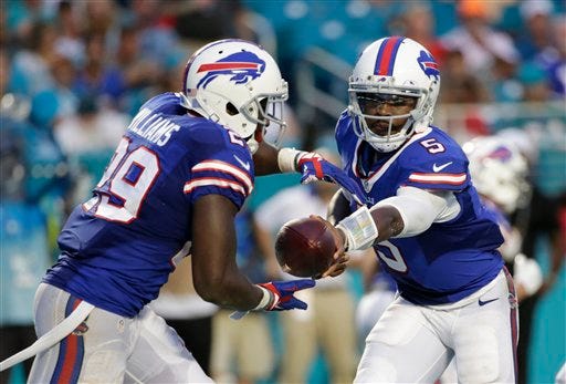 Buffalo Bills quarterback Tyrod Taylor (5) hands the ball to Buffalo Bills running back Karlos Williams (29) during the second half of an NFL football game against the Miami Dolphins, Sunday, Sept. 27, 2015 in Miami .