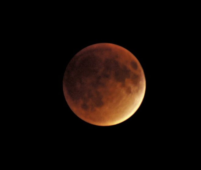 The moon took on a reddish glow by about 10:21 p.m. as it was positioned in the Earth's shadow.