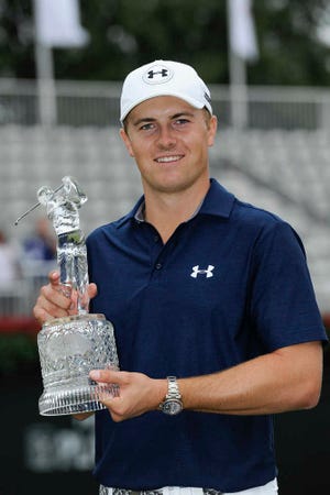 Jordan Spieth holds up the trophy after winning the Tour Championship Golf Tournament at East Lake Golf Club Sunday, Sept. 27, 2015. (AP Photo/John Amis)