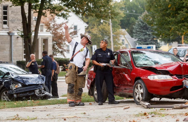 A Springfield Firefighter shows a Springfield Police officer a leaning power pole at the intersection of South Pasfield Street and South Grand Avenue after a two car accident Monday, Sept. 28, 2015. One person was hospitalized. Ted Schurter/The State Journal-Register