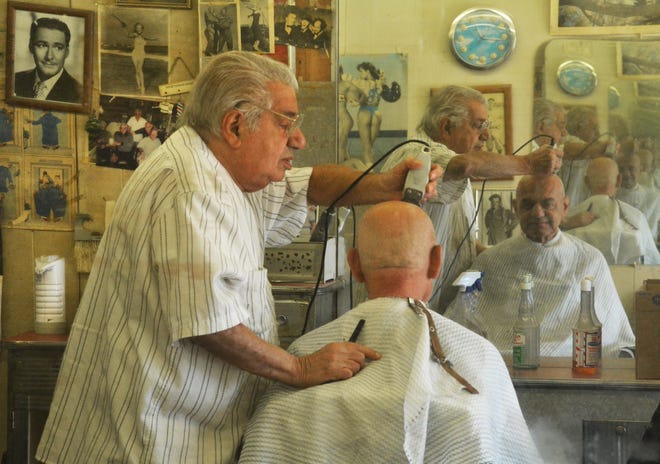 After 61 years as a barber, Sam Kazarian, 86, gives one of his his last haircuts Monday to longtime customer Samir Sakhat. Photo/Chris Christo