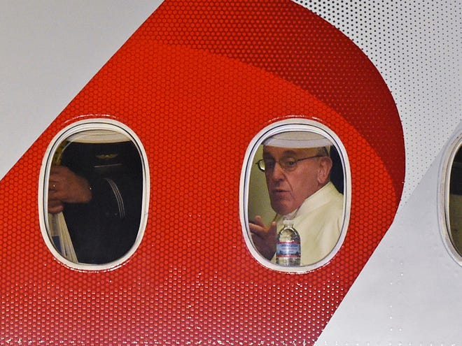 Pope Francis looks out the window a plane as he prepares to depart Philadelphia International Airport in Philadelphia Sunday on his way back to Rome.