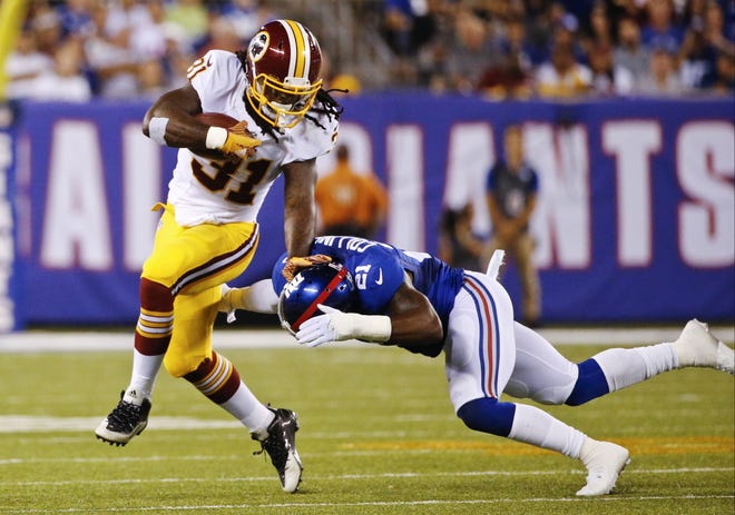 FILE - In this Sept. 24, 2015 file photo, Washington Redskins running back Matt Jones (31) stiff arms New York Giants' Landon Collins (21) during the first half an NFL football game in East Rutherford, N.J. Coach Jay Gruden and the Redskins get back to work Monday, Sept. 28, hoping to fix all of their problems before hosting NFC East rival Philadelphia next weekend. Coverage by freelancer Ian Quillen.(AP Photo/Kathy Willens)