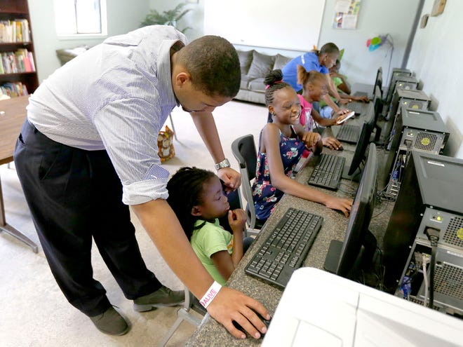 In this July 16 file photo, Fremon Williams helps kids with educational computer games at the Boys & Girls Club in Gainesville. The Alachua County Commission moved funds to assure funding for the nonprofit on Tuesday.