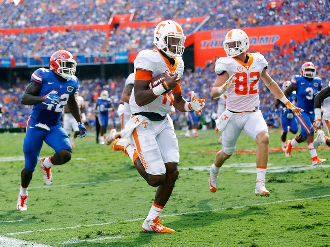 Tennessee quarterback Joshua Dobbs runs past Florida defensive back Keanu Neal for a touchdown during the first half Saturday at Florida Field.