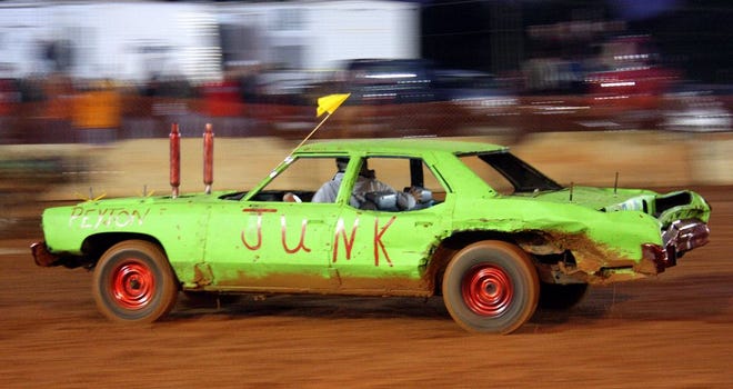 A green, late-model car speeds through the mud to avoid other cars in the Ultimate Destruction Demolition Derby at the Cleveland County Fair. The competition event will be offered two nights during the run of the fair this year. (Star file photo)