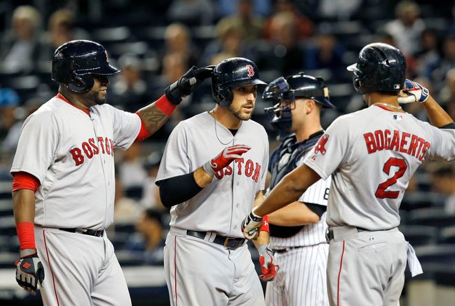 Boston Red Sox designated hitter David Ortiz, left, congratulates Red Sox first baseman Travis Shaw after he and Xander Bogaerts (2) scored on Shaw's first-inning three-run home run off New York Yankees starting pitcher Masahiro Tanaka in a baseball game in New York, Wednesday, Sept. 30, 2015.