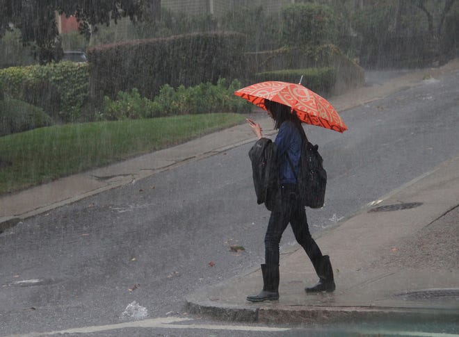 A pedestrian braves Wednesday's downpour in Providence. The Providence Journal/Steve Szydlowski