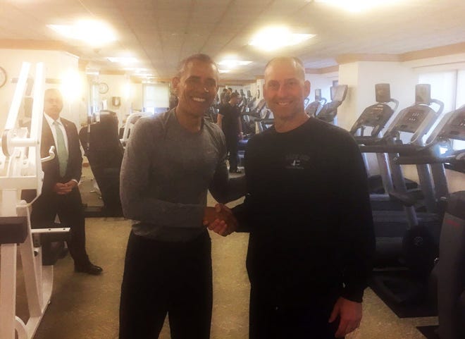 In this photo provided by the Boston Red Sox, President Obama shakes hands with Torey Lovullo in the exercise room of the New York Palace Hotel on Tuesday.
