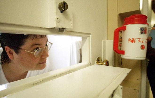 FILE - In this July 6, 2004, file photo, Kelly Renee Gissendaner, the only woman on Georgia's death row, looks through the slot in her cell door as a guard brings her a cup of ice at Metro State Prison in Atlanta. After several denied appeals, including several from the United States Supreme Court, Georgia executed its only female death row inmate Wednesday, Sept. 30, 2015. (Bita Honarvar/Atlanta Journal-Constitution via AP, File)