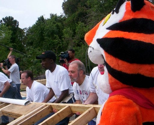 Herb Scheidel of Ponte Vedra Beach (third from right) gets help from Tony the Tiger and others while raising a wall at a Beaches Habitat home in Atlantic Beach in June 2005. Scheidel also helped finance the Habitat for Humanity project.