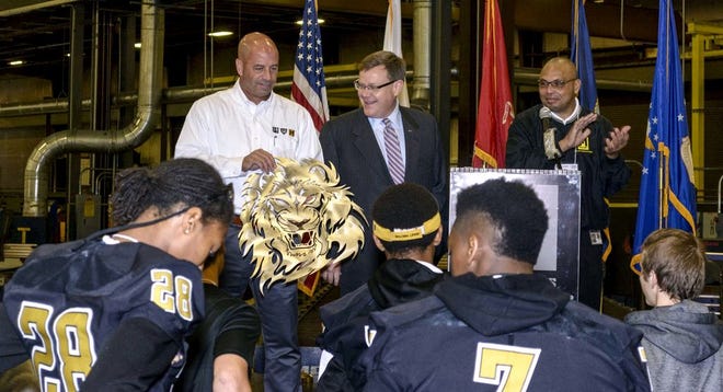 Metal Works Manufacturing Co. CEO and President Phil Spiro and House Speaker Tim Moore present students from Shelby High School with a metal sculpture of the school's Golden Lion mascot. The company made a sculpture for each of Cleveland County's four traditional schools and Turning Point Academy at their Manufacturing Day event at the Metal Works headquarters in Shelby. The event was scheduled to teach students, educators, local leaders and elected officials about manufacturing and its importance in Cleveland County.