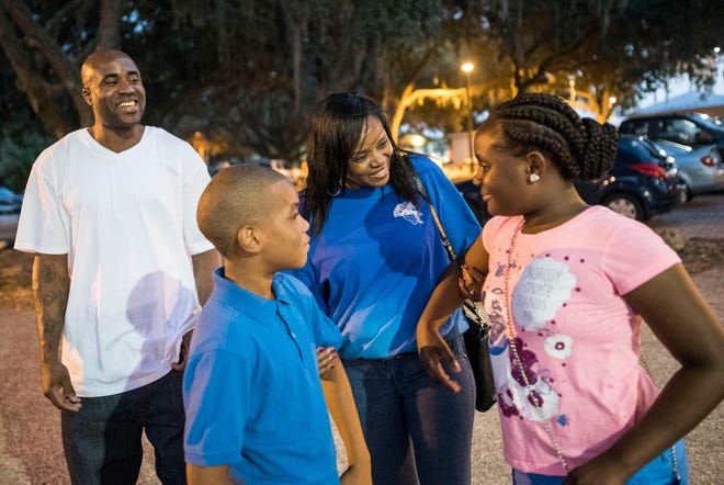 Andre Bryant talks with his mother, Zina Johnson, and children, Andre and Andrea, both 9, Friday night at Lincoln Park in Palmetto. Bryant was released from prison Thursday after having his conviction and sentence vacated for a 2006 robbery in Bradenton.
