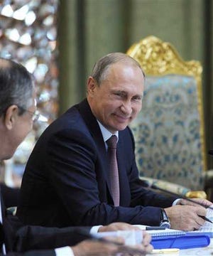Russian President Vladimir Putin smiles as he listens to Russia's Foreign Minister Sergey Lavrov, left, at the meeting of the Collective Security Treaty Organization (CSTO) in Dushanbe, Tajikistan, Tuesday, Sept. 15, 2015. Russian President Vladimir Putin on Tuesday strongly defended Moscow's military assistance to the Syrian government, saying it's impossible to defeat the Islamic State group without cooperating with the Syrian government. (Mikhail Klimentyev/RIA-Novosti, Kremlin Pool Photo via AP)