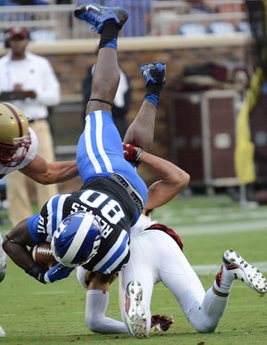 Duke's David Reeves (80) is upended by Boston College's Justin Simmons for a first down during an NCAA college football game, Saturday, Oct. 3, 2015, in Durham, N.C. (Bernard Thomas(/The Herald-Sun via AP) MANDATORY CREDIT