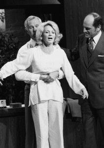 On the "Tonight Show" in 1978, host Johnny Carson performs the Heimlich maneuver on actress Angie Dickinson as Dr. Henry Heimlich looks on.