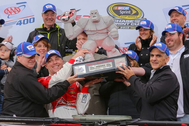 Kevin Harvick and his crew hoist the "Miles the Monster" trophy after winning Sunday's Sprint Cup race at Dover International Speedway.