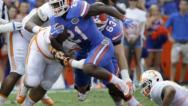 FILE - In this Sept. 26, 2015, file photo, Florida running back Kelvin Taylor (21) runs against Tennessee during the first half of an NCAA college football game in Gainesville, Fla. Kelvin Taylor was publicly ripped and then benched following a throat-slash gesture last month. He bounced back to become a leader and offensive workhorse for the 25th-ranked Gators. (AP Photo/John Raoux, File)