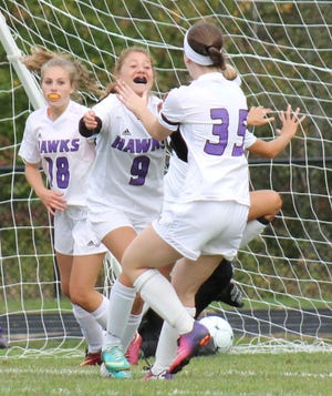 With the ball visible in the net behind her, Marshwood's Zoe Janetos (9) celebrates her first-half goal with teammates Mya Cartmill (18) and Hannah Fife (35) during Class A action Monday in South Berwick. Al Pike/fosters.com