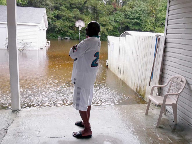 Tim Hemingway watches the water rise at his home outside of Conway, S.C., Sunday, Oct. 4, 2015. Hundreds were rescued from fast-moving floodwaters Sunday in South Carolina as days of driving rain hit a dangerous crescendo that buckled buildings and roads, closed a major East Coast interstate route and threatened the drinking water supply for the capital city. (Janet Blackmon Morgan/The Sun News via AP) LOCAL PRINT OUT (MYRTLE BEACH HERALD OUT, HORRY INDEPENDENT OUT, CAROLINA FOREST CHRONICLE, GEORGETOWN TIMES OUT); MANDATORY CREDIT