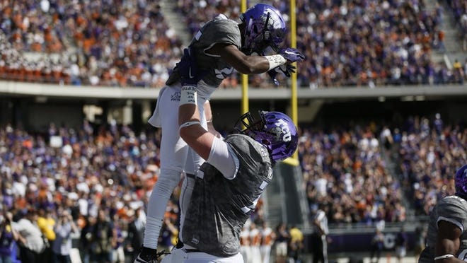 TCU wide receiver KaVontae Turpin (25) is congratulated by offensive guard Bobby Thompson (72) after scoring a touchdown during the first half against Texas at Amon G. Carter Stadium in Fort Worth, Texas, on Saturday, Oct. 3, 2015. TCU won, 50-7. (Brandon Wade/Fort Worth Star-Telegram/TNS)