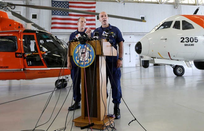 Capt. Mark Fedor, right, chief of response for the Coast Guard 7th District, talks to during a news conference as Lt. Commander Gabe Somma, left, listens, Monday, Oct. 5, 2015, at the Opa-locka Airport in Opa-locka, Fla. The Coast Guard said Monday that a U.S. cargo ship carrying 33 people that has been missing since it encountered high winds and heavy seas from Hurricane Joaquin sank and one body was found, but planes and ships will continue searching for the missing crew. (AP Photo/Alan Diaz)