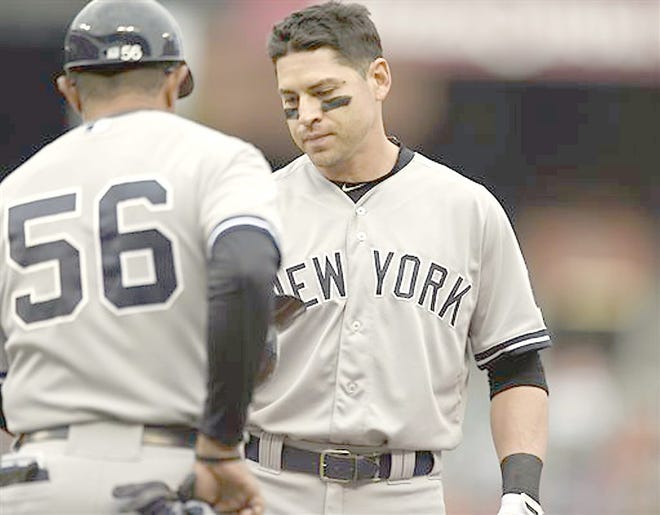 New York Yankees Jacoby Ellsbury (right) gives his helmet to first base coach Tony Pena after grounding out in the fourth inning Sunday against the Baltimore Orioles. 

AP Photo/Gail Burton