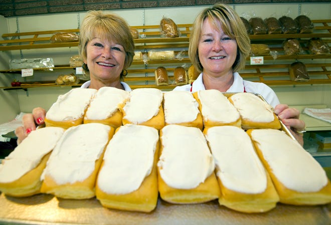 Owners Pam Simpson and Karen Speltz hold a tray of their famous maple squares at Harvey's Bakery in Dover. Photo by John Huff/Fosters.com