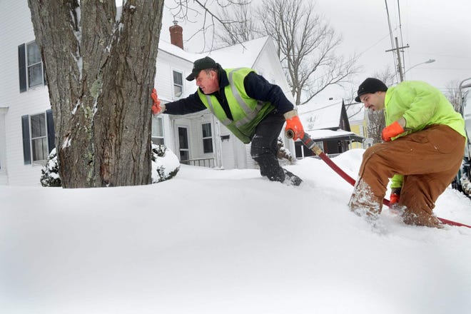 P. Gagnon & Son Oil delivery driver Bruce Goodwin, left, and assistant Phil Amato, trudge through high snow to get to a home on Butler Street in South Berwick, Maine, following yet another storm that hit the Seacoast last winter. File photo by Deb Cram/Seacoastonline