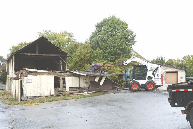 Welsh Run Builders took down the top level of a structure on the vacant Antrim Building and Farm Supply site on Friday.