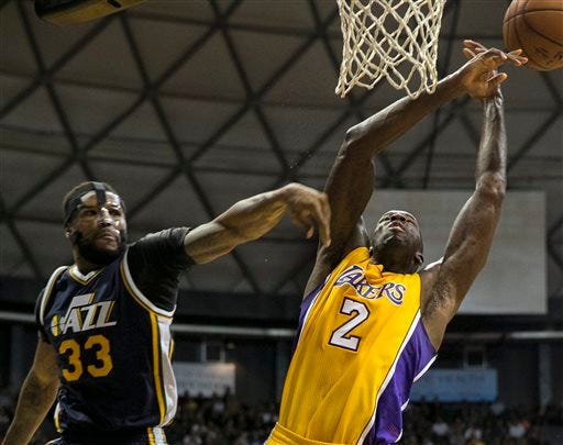 Utah Jazz forward Trevor Booker (33) fouls Los Angeles Lakers forward Brandon Bass (2) during the first half of an NBA preseason basketball game, Tuesday, Oct. 6, 2015, in Honolulu. (AP Photo/Marco Garcia)