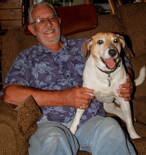 Paul Clement Sr. and his dog Otter sitting on the couch Tuesday afternoon in their home would like to thank his unknown neighbor that called the Rochester police early Saturday morning when they heard Otter crying deep in the woods. Two officers went into the woods and through the swamp and rescued Otter trapped in heavy underbrush by his collar and couldn't get home. Photo by Shawn St.Hilaire/Fosters.com