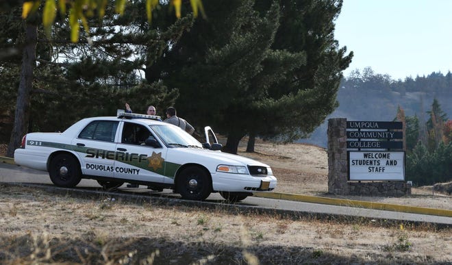 A Douglas County Sheriff's Deputy watches on the roads leading into the Umpqua Community College in Roseburg Tuesday morning. (Chris Pietsch/The Register-Guard)