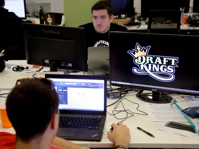 In this Sept. 9, 2015, file photo, Len Don Diego, marketing manager for content at DraftKings, a daily fantasy sports company, works at his station at the company's offices in Boston. New York's attorney general has sent letters to daily fantasy sports websites DraftKings and FanDuel demanding they turn over details of any investigations into their employees on Tuesday, Oct. 6, 2015.
