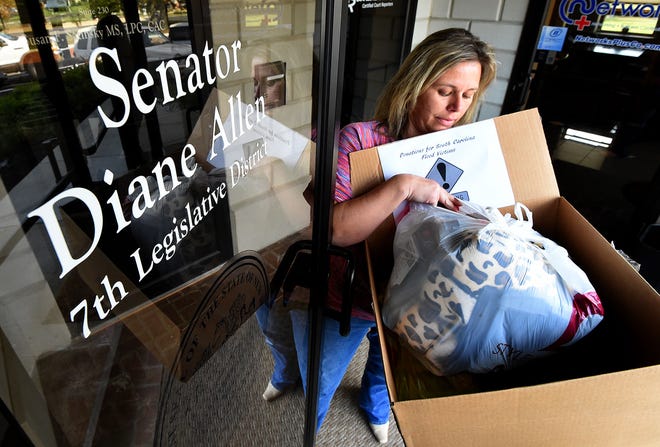 Jennie Lamon, chief of staff for Sen. Diane Allen, carries a box of donated goods for the flood victims in South Carolina out the legislative office in Cinnaminson on Thursday, Oct. 8, 2015. The office was a drop off location for items that will be sent to South Carolina on Friday.
