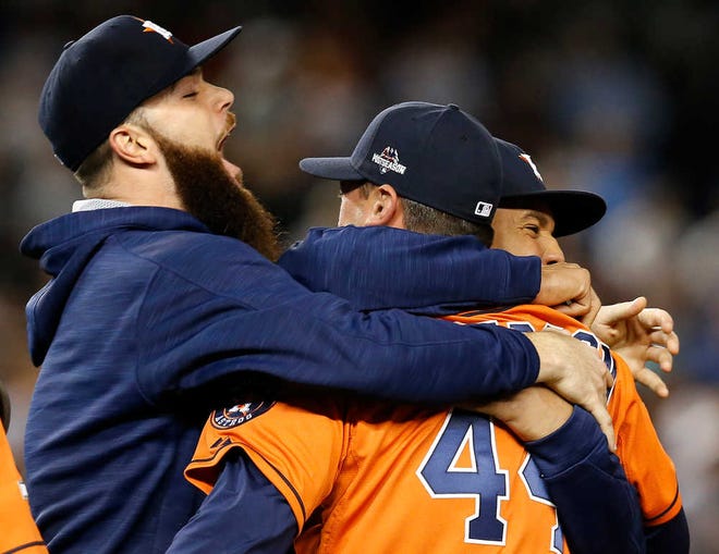 Houston Astros starting pitcher Dallas Keuchel, left, embraces Astros relief pitcher Luke Gregerson (44) and center fielder Carlos Gomez, right, as they celebrate the Astros 3-0 shutout of the New York Yankees in the American League wild card baseball game at Yankee Stadium in New York, Tuesday, Oct. 6, 2015. (AP Photo/Kathy Willens)