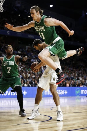 The Celtics' Kelly Olynyk, top, falls over Real Madrid's Felipe Reyesd during an exhibition game Thursday in Madrid. The Associated Press