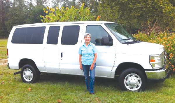 Dr. Carole Ludwig in front of the new 12-passenger van she was able to purchase with donations to transport military veterans to their medical appointments around the state. Photo contributed